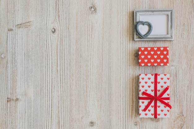 Free photo gray frame and polka dot gifts on a wooden table