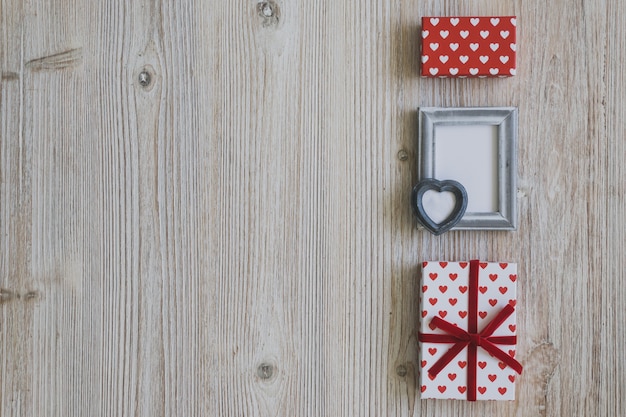 Free photo gray frame and polka dot gifts on a wooden table