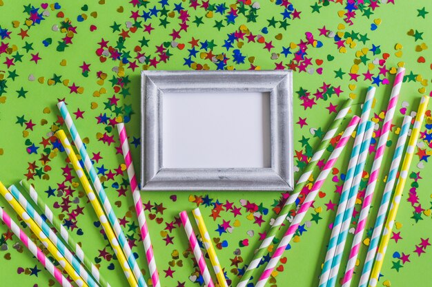 Gray photo frame with confetti and colorful sticks