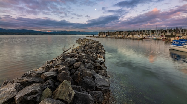 Gray Rocks Near Body of Water Under Blue Sky