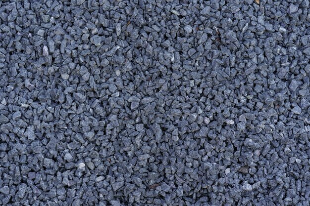 Gray small rocks ground texture. Dark gray small road stone background.