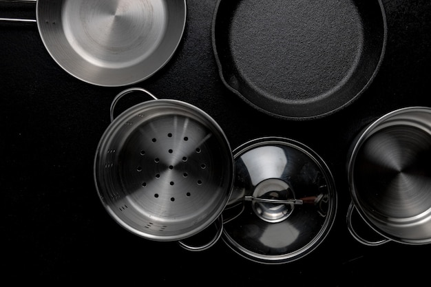 Grayscale overhead shot of metal pot frying pan a lid