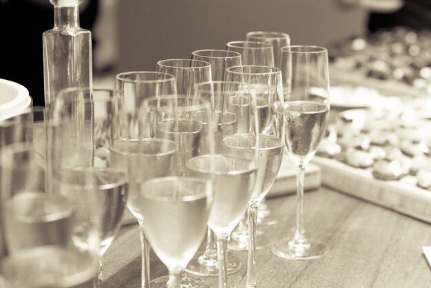 Grayscale shot of glasses filled with champagne