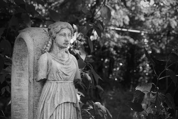 Free photo grayscale shot of stone sculptures in a garden