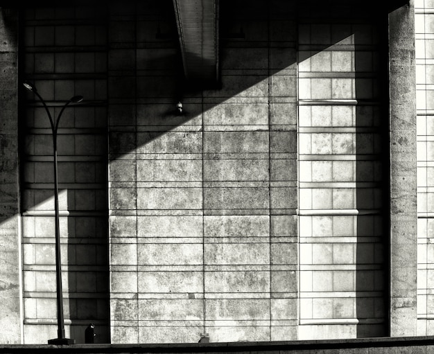 Free Photo grayscale symmetric shot of a stone shadowed wall - depression, solitude concept