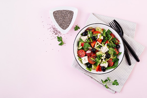 Greek salad  with cucumber, tomato, sweet pepper, lettuce, green onion, feta cheese and olives with olive oil. Healthy food. Top view