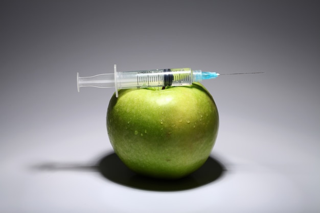 Free photo green apple and syringe