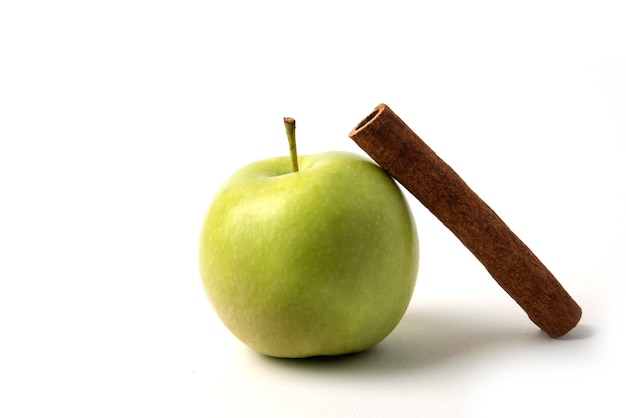 A green apple with a cinnamon stick around