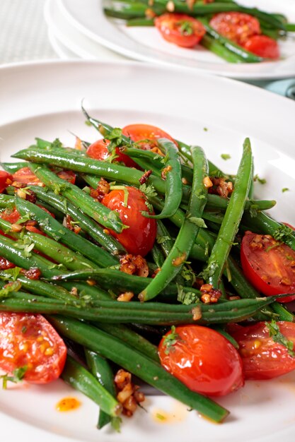 Green beans and tomato salad on white plate