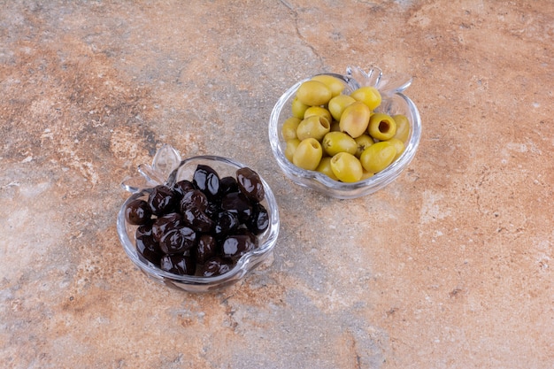 Green and black olives in glass cups