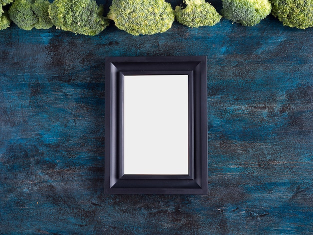 Green broccoli with blank frame on table 