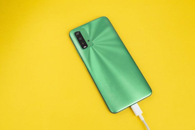 Green cell phone connected to USB cable type C - Charging