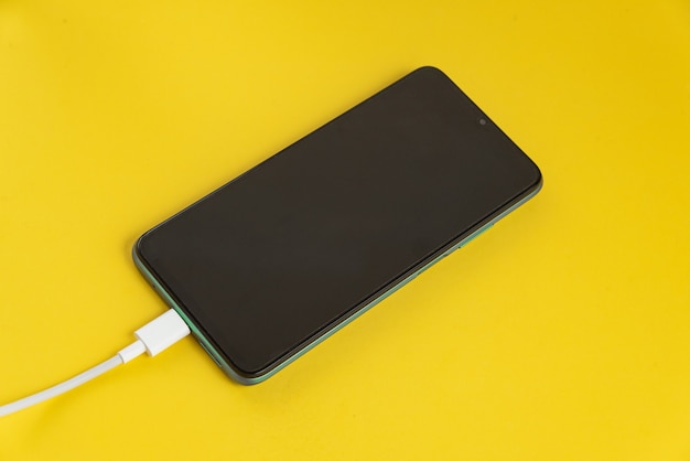 Green cell phone connected to USB cable type C - Charging