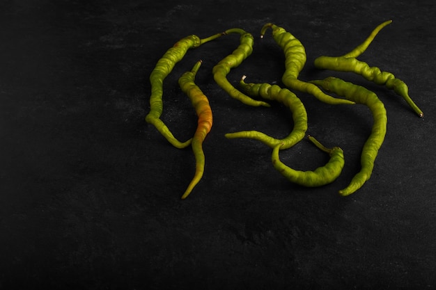 Free photo green chilies isolated on black surface.