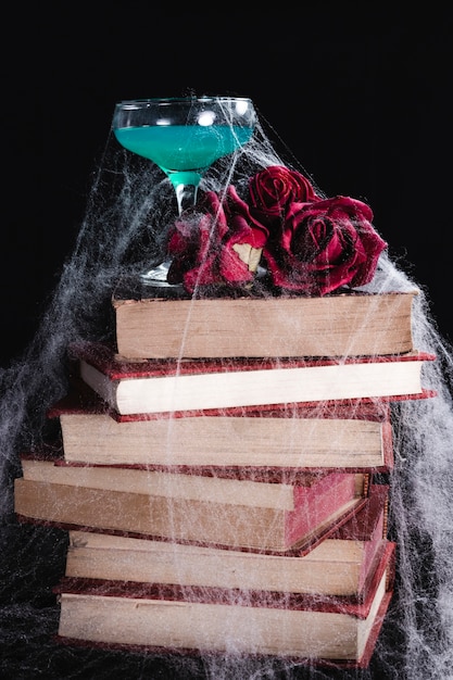 Free photo green drink with roses, books and spider web