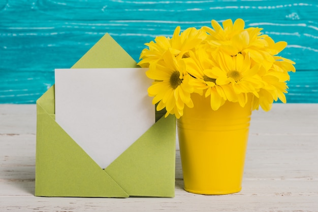 Green envelope with piece of paper and yellow flowers