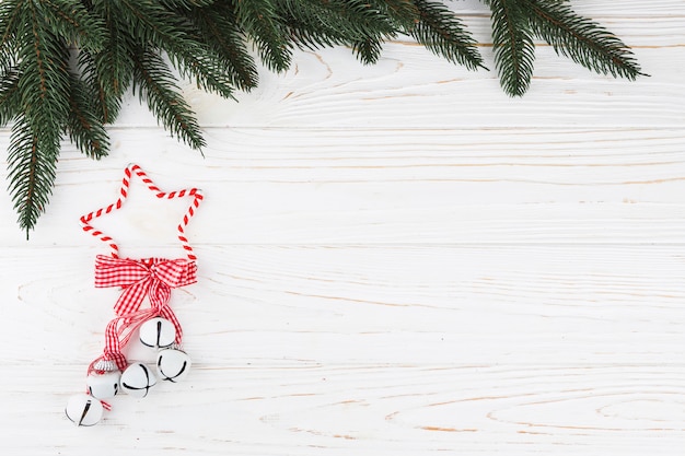 Free Photo green fir tree branches with jingle bells on table 