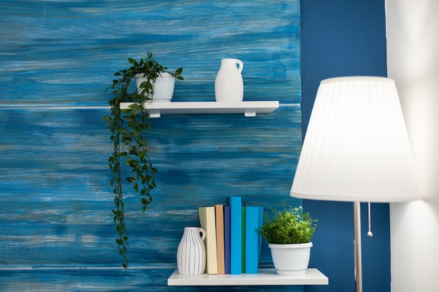 Green flowers on white shelf in blue room