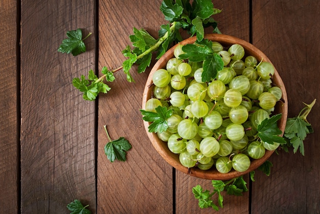 Green gooseberries in a wooden bowl