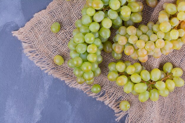 Green grape bunches on piece of burlap.