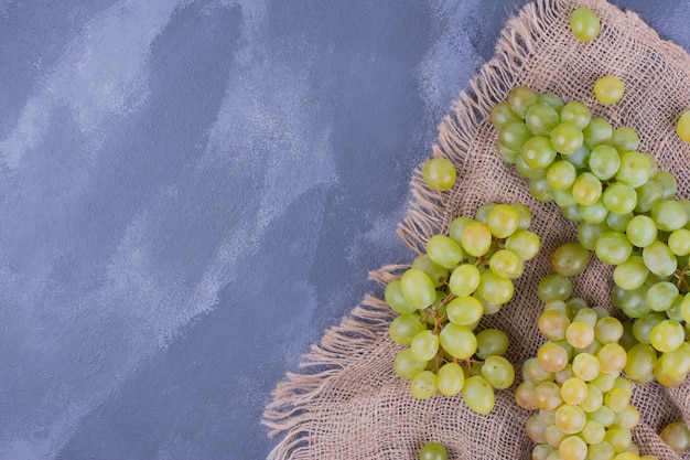 Green grape bunches on a piece of burlap.