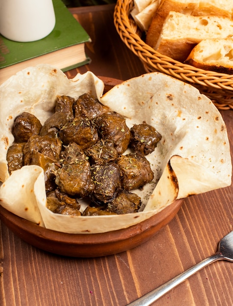 Green grape leaves stuffed with meat, rice, herbs, onion and cooked in olive oil, served with lavash and bread.yarpag dolmasi, yaprak sarmasi. 