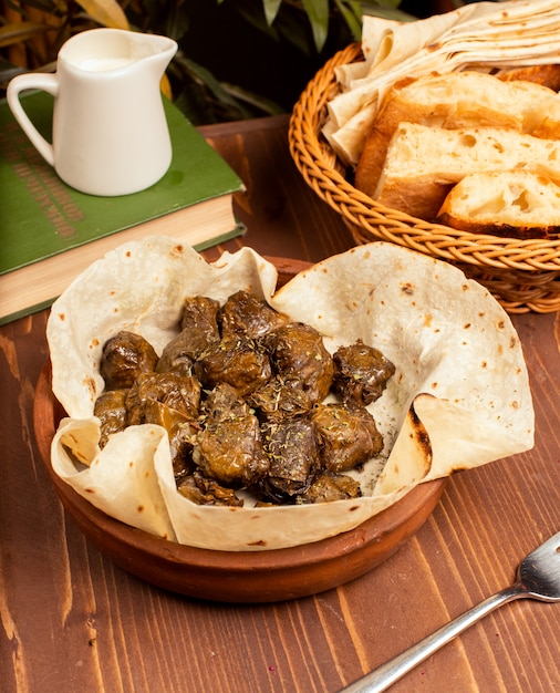 Green grape leaves stuffed with meat, rice, herbs, onion and cooked in olive oil, served with lavash and bread.yarpag dolmasi, yaprak sarmasi