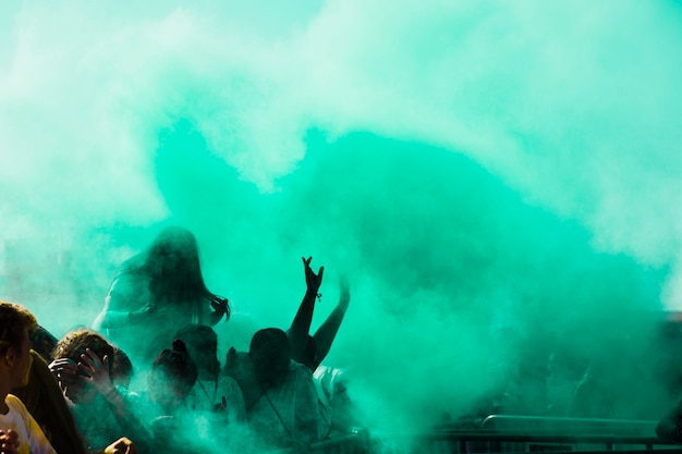 Green holi color powder over the crowd