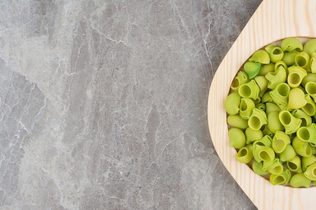 Green homemade pastas in plates on the grey space. 