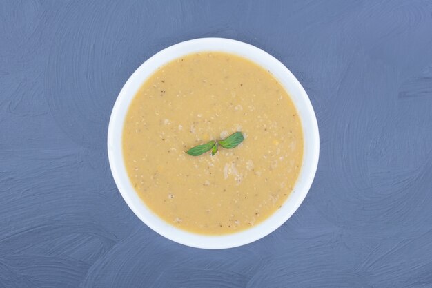 Green lentil beans soup in a white plate.