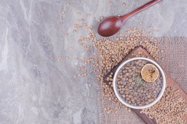 Green lentil soup in a white bowl on the wooden board