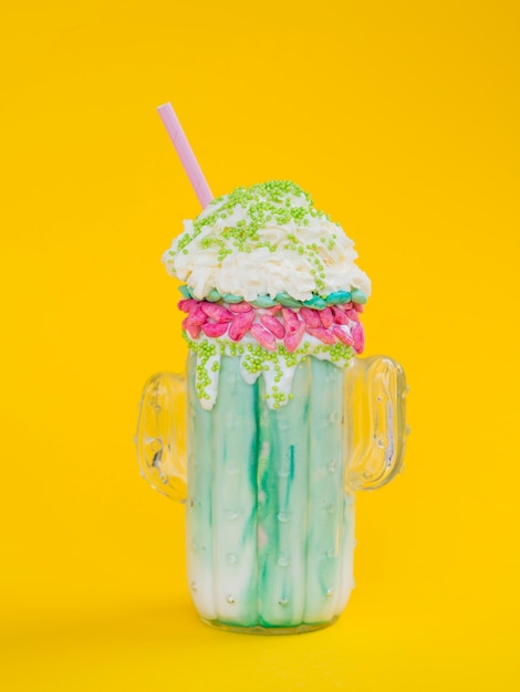 Free photo green milkshake on yellow background