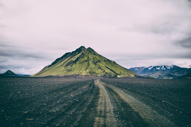 Green mountain under cloudy sky