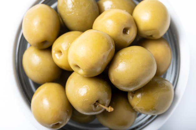 Free photo green olives in white bowl isolated on white background