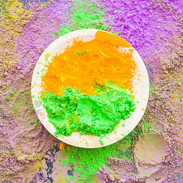 Free photo green and orange traditional holi powder on plate