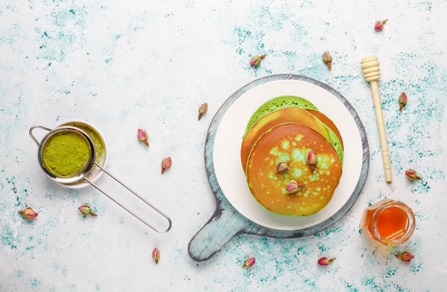 Free Photo green pancakes with matcha powder with red jam, top view