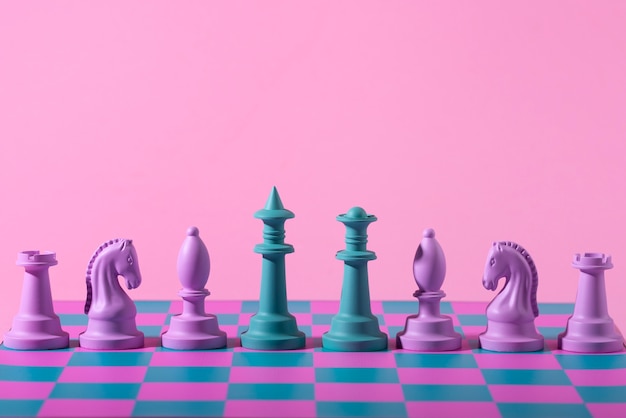 Free photo green and pink pieces for chess with game board