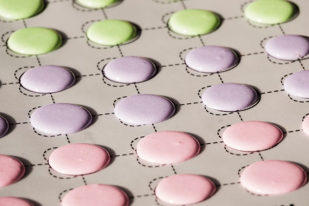 Free photo green; pink and purple macaroons shells on a slip mat