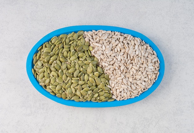 Green pumpkin and sunflower seeds in a platter. 