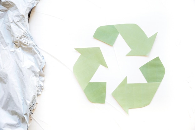 Green recycle logo with plastic trash