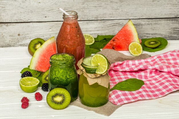 green and red smoothies in a jar with lime, kiwi