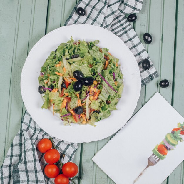 Green salad with lettuce and black olives. Top view.