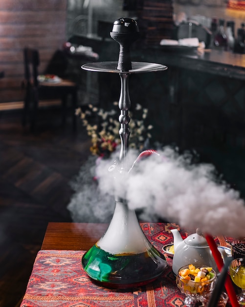 Free Photo green steaming hookah on the table tea side view