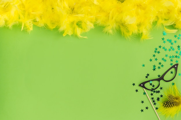 Green table with yellow feathers on the top and purple glasses