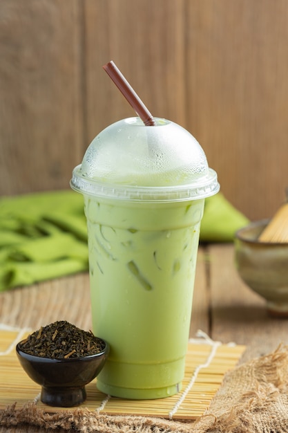 Green tea, iced milk and matcha powder on wooden floor.