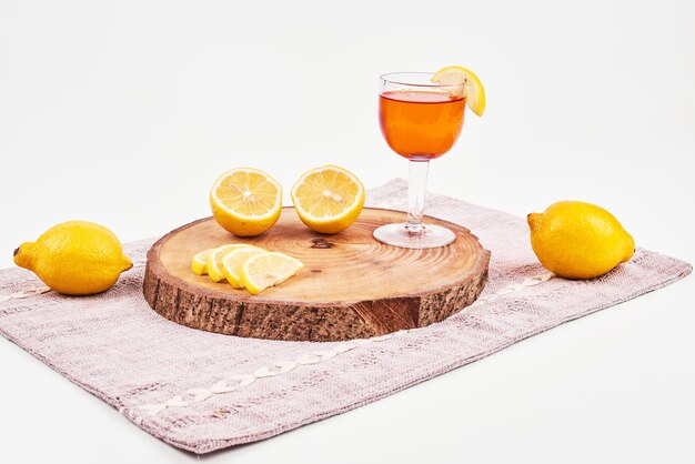 Green tea with lemons on white surface. 