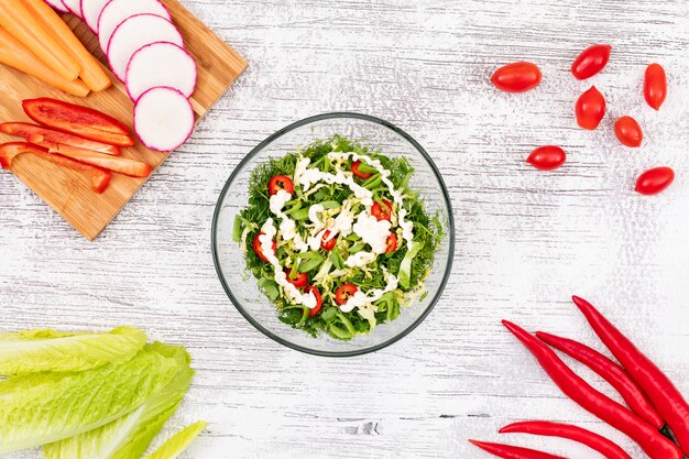 Green vegetable salad in glass plate on the table top view