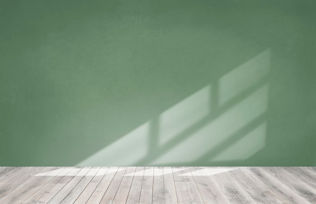 Green wall in an empty room with a wooden floor