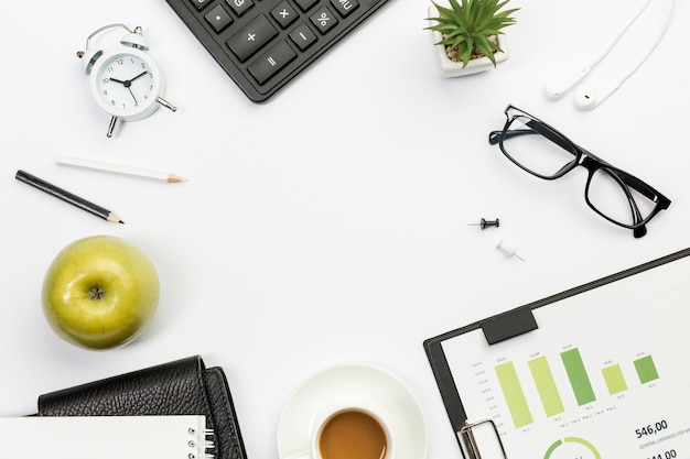 Green whole apple with stationeries on white office desk