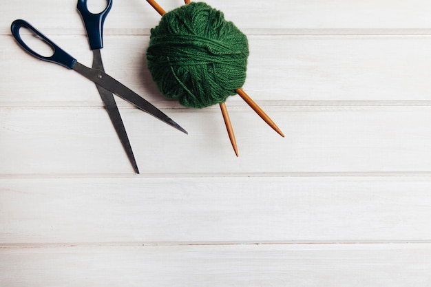 Free photo green wool ball and scissors